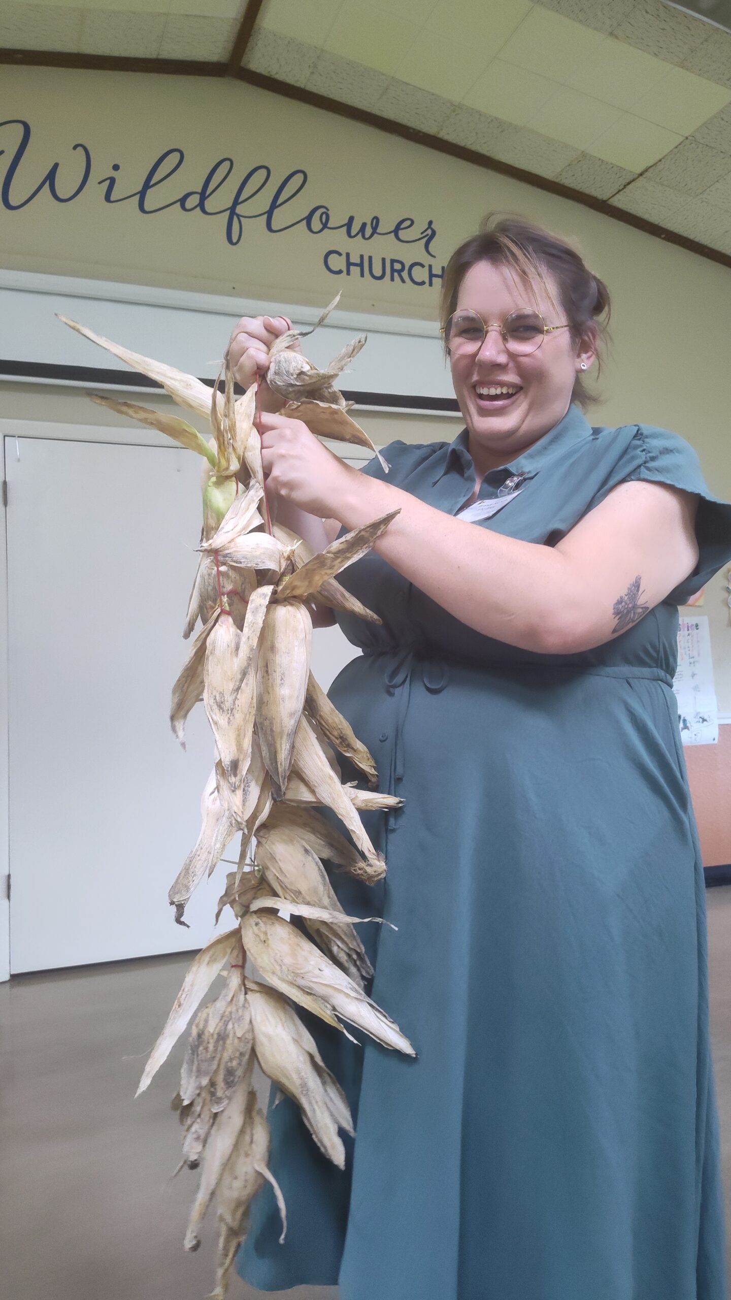 Brandy Nichols holds a string of corn in the husks in the Wildflower Community Room